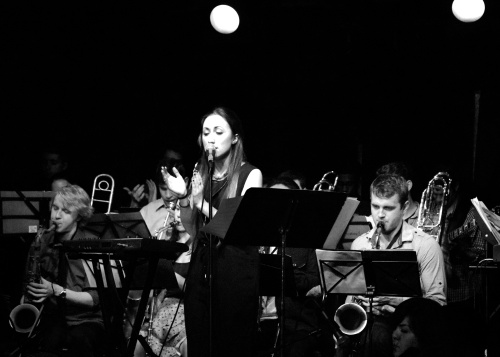 Sean Little is playing tenor to my left, Christopher Misch-Bloxdorf is playing trombone right behind me, Laura Huey is playing viola on the ground, Sam Neufeld is playing trumpet way in the back, Jill Ryan is playing alto right behind me and Owen Dudley is playing guitar in the far right hand corner. 
